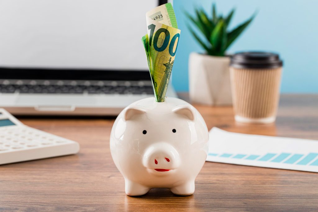 Professional desk setup with a pink piggy bank, highlighting business savings and financial planning