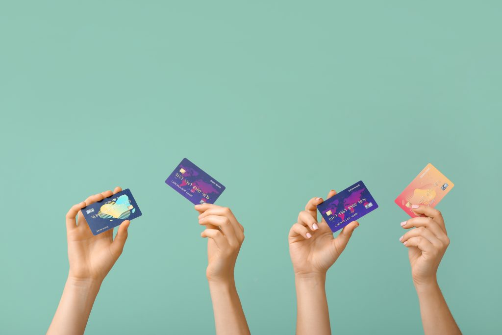 Female hands with credit cards on color background